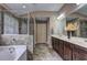 Well-lit bathroom with double vanity, soaking tub, walk-in shower, and tile floor at 1239 Side Step Trace, Lawrenceville, GA 30045