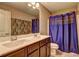 Bathroom featuring double sink vanity, large mirror, and a shower with blue curtain at 1239 Side Step Trace, Lawrenceville, GA 30045