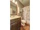 Nicely appointed bathroom featuring a tub/shower with a patterned curtain and wood floors at 1239 Side Step Trace, Lawrenceville, GA 30045