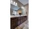 Bathroom with dual sink vanity with dark wood cabinetry, large mirror and stylish lighting at 1239 Side Step Trace, Lawrenceville, GA 30045