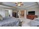 Bright spacious bedroom featuring tray ceiling, windows, and dresser at 1239 Side Step Trace, Lawrenceville, GA 30045