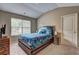 Bedroom with a large bed, vaulted ceiling, and a window overlooking a wooded area at 1239 Side Step Trace, Lawrenceville, GA 30045