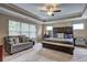 Bright spacious bedroom featuring tray ceiling, windows, and comfortable seating at 1239 Side Step Trace, Lawrenceville, GA 30045