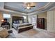 Bright spacious bedroom featuring tray ceiling, windows, bed, and dresser at 1239 Side Step Trace, Lawrenceville, GA 30045
