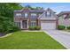 Charming two-story brick home with well-manicured lawn and a two car garage at 1239 Side Step Trace, Lawrenceville, GA 30045