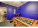 Game room with blue walls showcasing a foosball table and partial view of the basement bar area at 1239 Side Step Trace, Lawrenceville, GA 30045