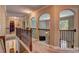 Hallway with an open view to downstairs, featuring arched entryways and decorative railings at 1239 Side Step Trace, Lawrenceville, GA 30045