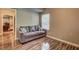 Comfortable sitting room with wood flooring, a soft couch and an adjacent living space at 1239 Side Step Trace, Lawrenceville, GA 30045
