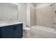 A full bathroom featuring a blue vanity, white toilet and shower and tub combo at 158 Palisade Dr, Rydal, GA 30171