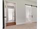 Bright hallway showing doors, one with a barn door, providing access to other rooms in the house at 158 Palisade Dr, Rydal, GA 30171