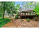 Charming home featuring a large deck, surrounded by lush green landscaping and mature trees at 845 Creek Trail Northwest Nw Trl, Kennesaw, GA 30144