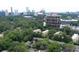 Aerial view of community with lush trees and an urban skyline in the background at 40 Olde Ivy Ne Sq, Atlanta, GA 30342