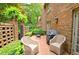Relaxing patio features brick pavers, wicker chairs, lush landscaping, and an outdoor grill at 40 Olde Ivy Ne Sq, Atlanta, GA 30342