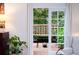 Living room view into a private brick-paved patio with lush greenery and stylish outdoor furniture at 40 Olde Ivy Ne Sq, Atlanta, GA 30342