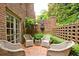Charming brick patio features four wicker chairs, a brick fountain, and lush landscaping for a relaxing outdoor space at 40 Olde Ivy Ne Sq, Atlanta, GA 30342