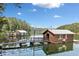 Exterior view of cozy boathouses on a calm lake, surrounded by lush trees and a serene blue sky at 451 Wilderness Camp Rd, White, GA 30184