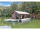 Cozy lake house featuring a dock, metal roof, and wooded surroundings offering a serene waterfront retreat at 451 Wilderness Camp Rd, White, GA 30184