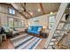 Cozy living room with a comfortable couch, rustic wooden ladder to the loft, and scenic lake views at 451 Wilderness Camp Rd, White, GA 30184