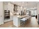 Gourmet kitchen featuring an island with seating, stainless steel appliances, and access to living room at 884 Mayfield Rd, Milton, GA 30009
