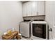 Functional laundry room featuring modern washer and dryer units with white cabinets above at 884 Mayfield Rd, Milton, GA 30009
