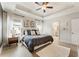 Bright main bedroom featuring a tray ceiling, large bed, and hardwood flooring at 884 Mayfield Rd, Milton, GA 30009