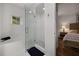 Bright bathroom featuring a tub, glass-enclosed shower, and a view into the main bedroom at 123 Ashford Cir, Atlanta, GA 30338