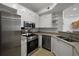 Modern kitchen with stainless steel appliances, white cabinets, and tile flooring at 123 Ashford Cir, Atlanta, GA 30338