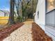 Side view of driveway flanked by trees and mulch alongside a white house with gray trim at 2068 Verbena Nw St, Atlanta, GA 30314