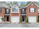 Brick townhome featuring a garage and black window shutters at 215 Morris Ln, Woodstock, GA 30188