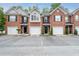Townhome exteriors showcase brick facades, garages, and dedicated parking at 215 Morris Ln, Woodstock, GA 30188