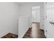 Hallway featuring hardwood floors, white walls, leading to sunlit rooms at 215 Morris Ln, Woodstock, GA 30188