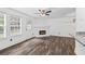 Bright living area features refinished hardwood floors, fan, and a brick fireplace at 215 Morris Ln, Woodstock, GA 30188