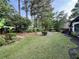 Beautifully landscaped backyard with lush lawn, mature trees and shrubbery, and mulched flowerbeds at 2610 Stokesley Way, Snellville, GA 30078