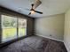 Cozy bedroom with large window providing a view of the landscaped yard and a ceiling fan at 2610 Stokesley Way, Snellville, GA 30078
