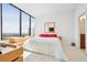 Bright bedroom with floor-to-ceiling windows offering city views and stylish wooden dresser at 2828 Peachtree Nw Rd # 2002, Atlanta, GA 30305