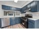 Modern kitchen featuring blue cabinets, stainless steel appliances, and light countertops at 3072 Revere Ct, Atlanta, GA 30340