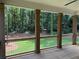 Inviting back porch with a railing and pillars, overlooking a serene wooded backyard at 4110 Post Gate Ct, Cumming, GA 30040