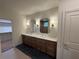Bathroom with a long dual sink vanity, marble countertop, framed mirrors, sconce lighting, and tile floors at 4110 Post Gate Ct, Cumming, GA 30040