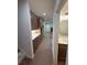 Long hallway featuring wood cabinets, marble countertops, lighting, and a glimpse into the living space at 4110 Post Gate Ct, Cumming, GA 30040