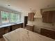 Kitchen featuring custom cabinets and a marble countertop island with a view to the wooded lot at 4110 Post Gate Ct, Cumming, GA 30040
