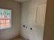Laundry room with a window for natural light and a cabinet for storage at 4110 Post Gate Ct, Cumming, GA 30040