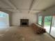 Living room featuring a stone fireplace, coffered ceilings, and sliding doors at 4110 Post Gate Ct, Cumming, GA 30040