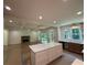 Open-concept living space with a fireplace, kitchen island, and large windows providing ample natural light at 4110 Post Gate Ct, Cumming, GA 30040