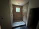 Modern shower featuring wood look tile walls, pebble floor, and a window at 4110 Post Gate Ct, Cumming, GA 30040