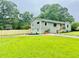 Exterior view of the house with a green lawn and mature trees at 1042 Oakdale Se Dr, Smyrna, GA 30080