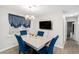 Dining area with stylish table, TV and blue tufted chairs. Luxury vinyl plank flooring and fresh paint at 200 Robin Hood Ln, Hampton, GA 30228
