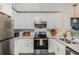 Bright kitchen features stainless steel appliances, white cabinets, and sleek countertops at 200 Robin Hood Ln, Hampton, GA 30228
