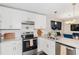 Well-lit kitchen boasts stainless appliances, white cabinets, and eat in counter at 200 Robin Hood Ln, Hampton, GA 30228