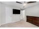 A carpeted main bedroom with a ceiling fan and adjoining bathroom at 200 Robin Hood Ln, Hampton, GA 30228