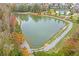 Scenic aerial view of a tranquil pond surrounded by lush greenery and walking trails at 3860 Oxford Park Ln, Cumming, GA 30040